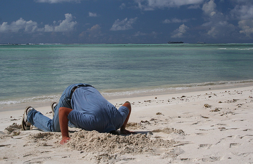 Man burying his head in the sand
